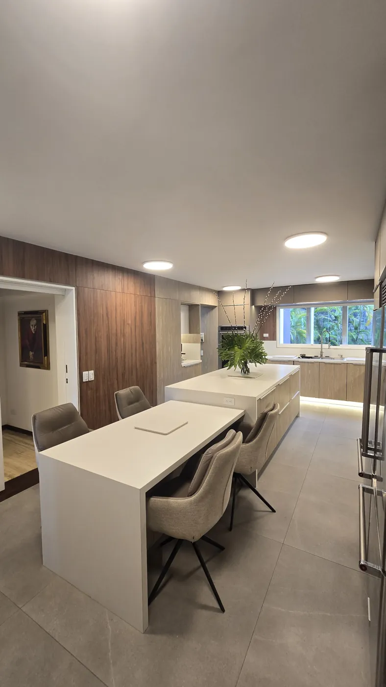 Cocina remodelada por Oscar: mesa unida a la isla y luz bajo los muebles